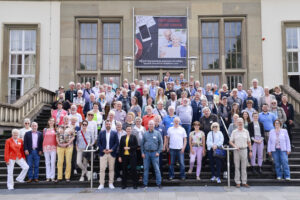 Auf dem Foto sieht man die über 100 Teilnehmenden vor der Treppe der Alten Mensa der Johannes Gutenberg-Universität Mainz.